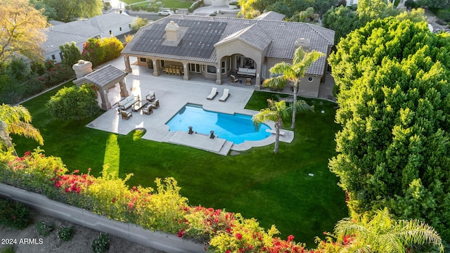 view of pool with outdoor lounge area, a patio area, an outdoor bar, and a lawn