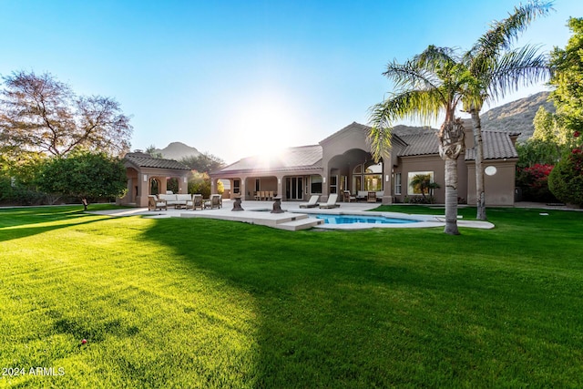 back of house featuring an outdoor living space, a pergola, a patio area, and a lawn