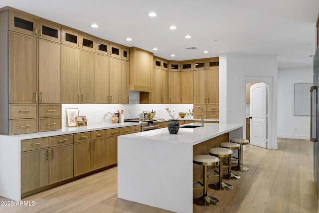 2774 E Valencia St, Gilbert, AZ 85296 - kitchen with a sink, backsplash, light wood-style floors, an island with sink, and recessed lighting
