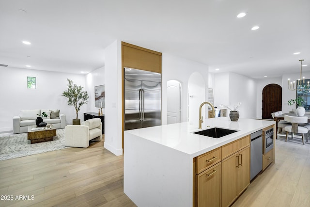 2774 E Valencia St, Gilbert, AZ 85296 - kitchen with built in appliances, arched walkways, a sink, open floor plan, and recessed lighting
