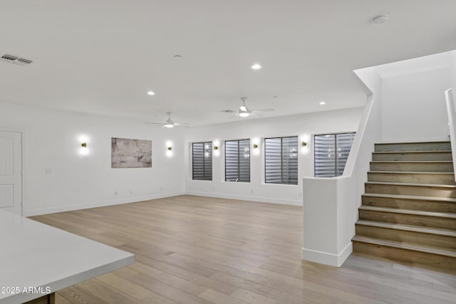 2774 E Valencia St, Gilbert, AZ 85296 - unfurnished living room with light wood-style flooring, ceiling fan, stairs, recessed lighting, and baseboards