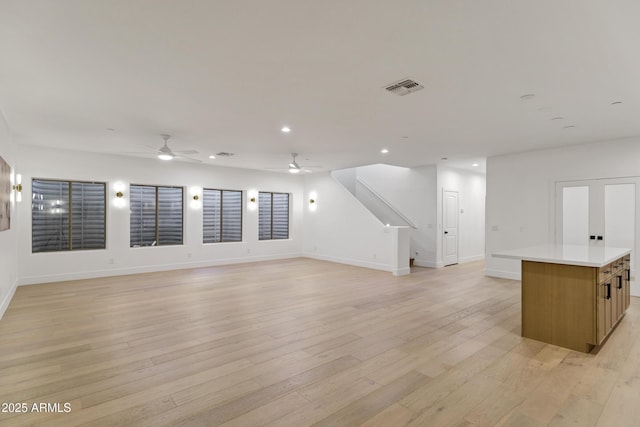 2774 E Valencia St, Gilbert, AZ 85296 - unfurnished living room featuring a ceiling fan, recessed lighting, light wood-style floors, baseboards, and stairs