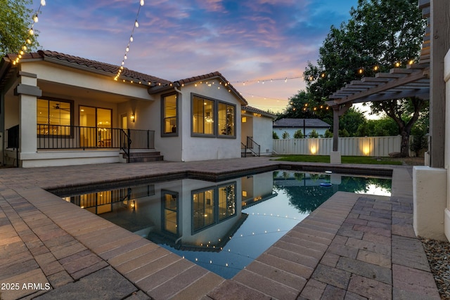 2774 E Valencia St, Gilbert, AZ 85296 - back of house at dusk featuring stucco siding, a patio, a tile roof, and a pergola