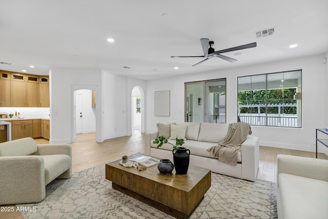 2774 E Valencia St, Gilbert, AZ 85296 - living room with arched walkways, ceiling fan, light wood-type flooring, recessed lighting, and baseboards