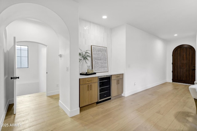 2774 E Valencia St, Gilbert, AZ 85296 - indoor dry bar featuring beverage cooler, arched walkways, light wood finished floors, recessed lighting, and baseboards