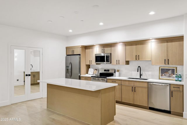 2774 E Valencia St, Gilbert, AZ 85296 - kitchen featuring appliances with stainless steel finishes, a sink, light wood-type flooring, a center island, and recessed lighting