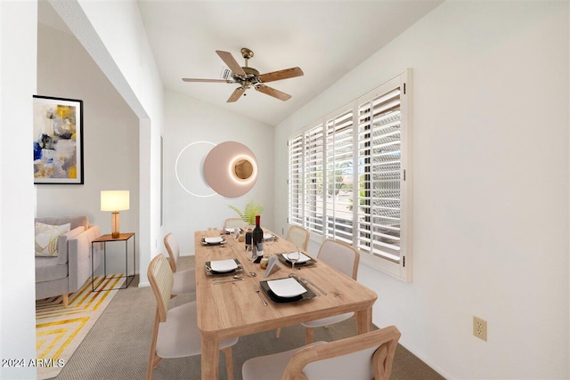 dining area featuring lofted ceiling, light colored carpet, and ceiling fan