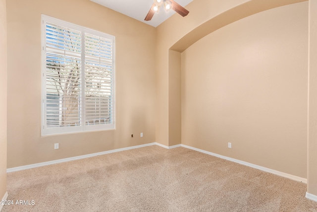 carpeted spare room featuring ceiling fan