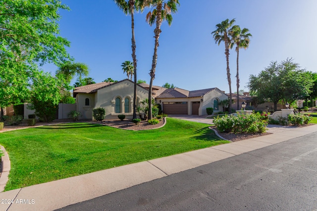 mediterranean / spanish-style house featuring a front lawn and a garage