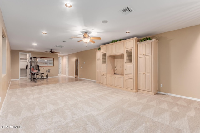 unfurnished living room featuring light carpet and ceiling fan