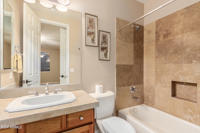 full bathroom featuring tiled shower / bath, toilet, and vanity