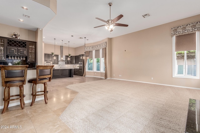 living room featuring a healthy amount of sunlight, light colored carpet, ceiling fan, and sink