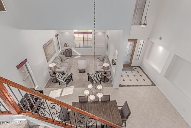 entrance foyer featuring a high ceiling, tile patterned flooring, baseboards, and stairway