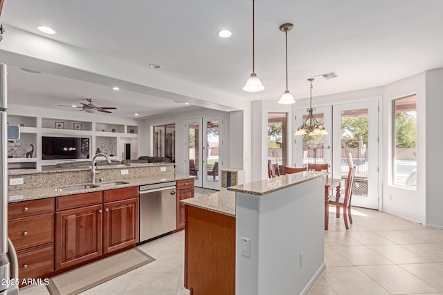 kitchen with brown cabinetry, light tile patterned flooring, open floor plan, a sink, and dishwasher