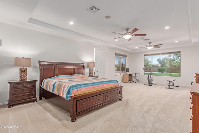 bedroom with recessed lighting, a tray ceiling, visible vents, and light carpet