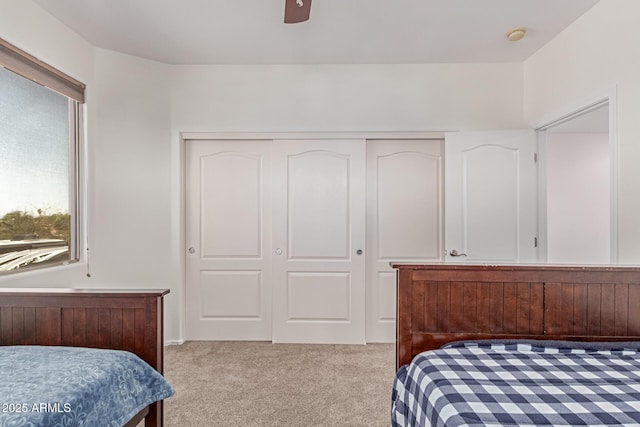 bedroom featuring ceiling fan, light carpet, and a closet