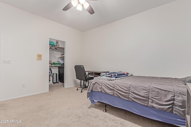bedroom with a closet, carpet flooring, baseboards, a walk in closet, and a ceiling fan