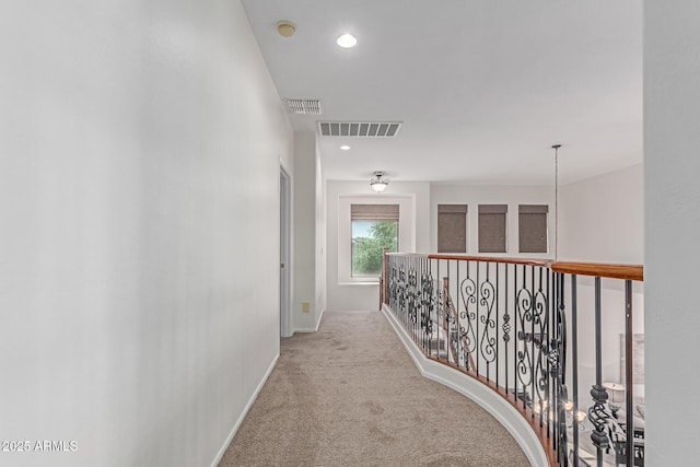hallway with carpet floors, recessed lighting, baseboards, and visible vents