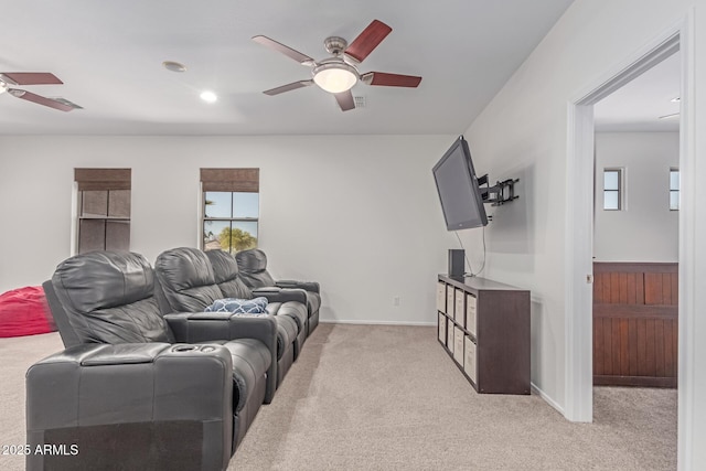 living room featuring baseboards, light carpet, and a ceiling fan