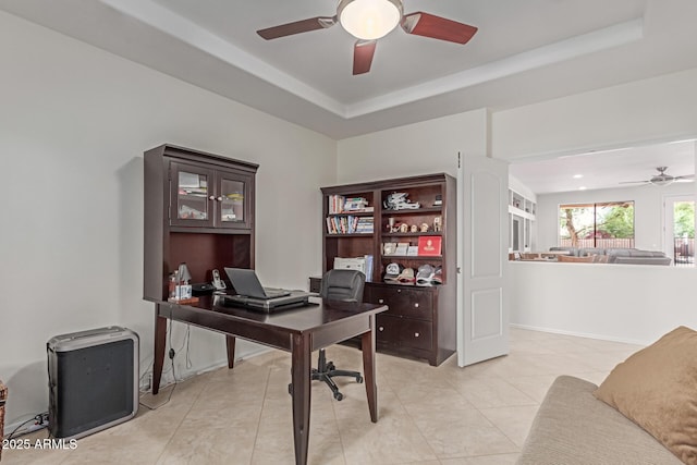 home office featuring baseboards, ceiling fan, light tile patterned floors, and a tray ceiling
