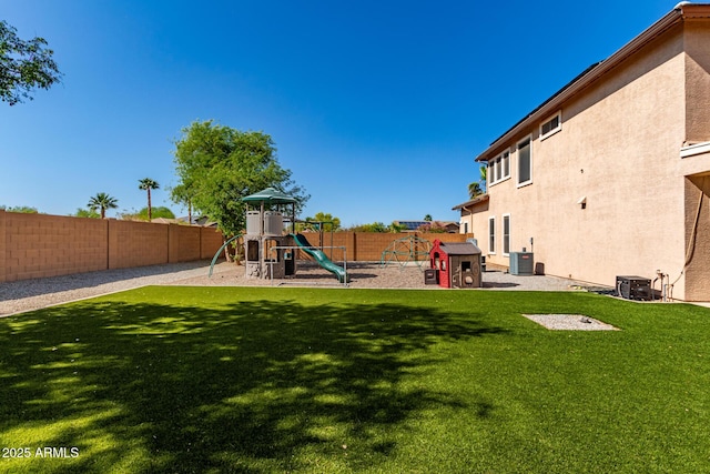 view of play area with a lawn, central AC, and a fenced backyard
