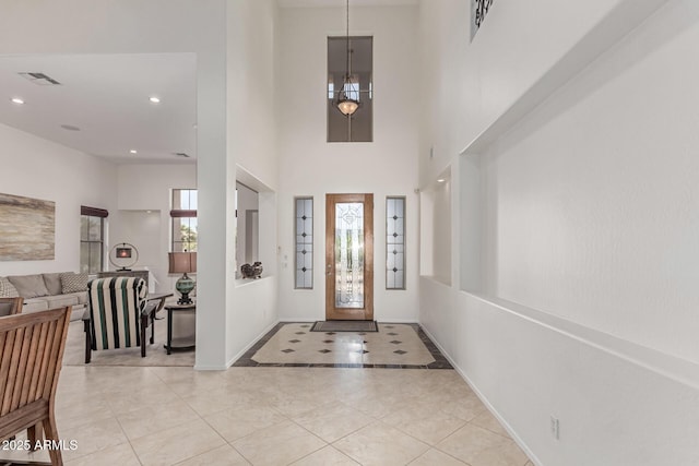 entryway with visible vents, a towering ceiling, baseboards, recessed lighting, and light tile patterned floors