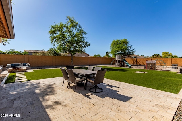 view of patio / terrace featuring outdoor dining area, a fenced backyard, a playground, and a fire pit