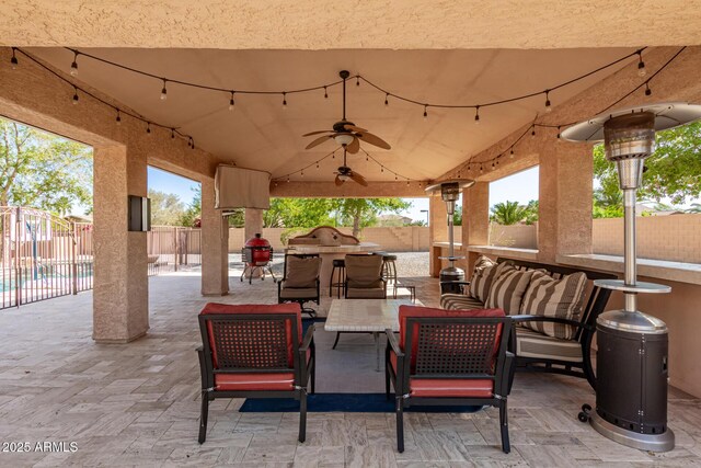 view of patio / terrace featuring ceiling fan, an outdoor living space, and a fenced backyard