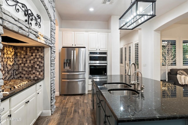 kitchen featuring white cabinetry, dark wood-type flooring, an island with sink, and stainless steel appliances