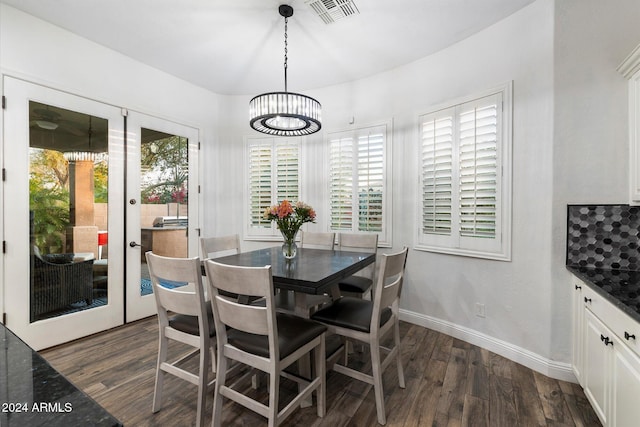 dining area featuring a notable chandelier, dark hardwood / wood-style flooring, and french doors