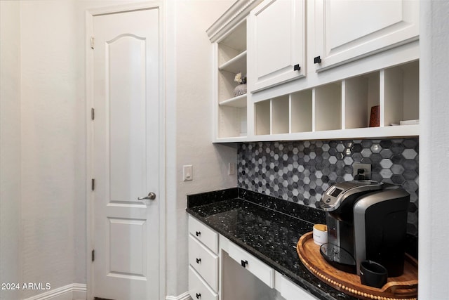 kitchen featuring white cabinets, dark stone countertops, and tasteful backsplash