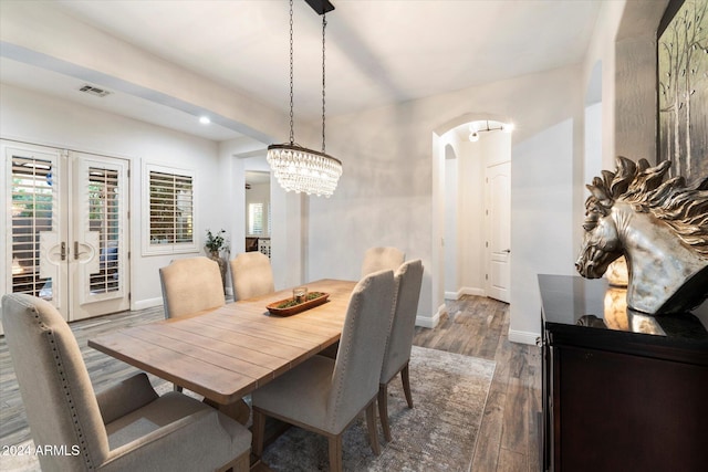 dining space with a notable chandelier, dark wood-type flooring, and french doors