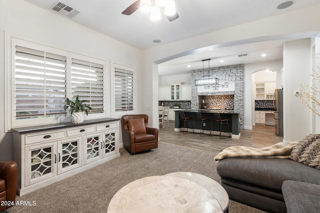 living room with ceiling fan and light hardwood / wood-style flooring