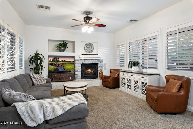 living room featuring carpet, ceiling fan, and a fireplace