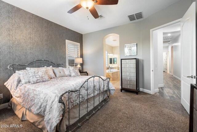 bedroom with ensuite bathroom, ceiling fan, and dark hardwood / wood-style floors