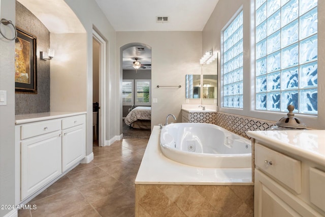 bathroom featuring tile patterned floors, ceiling fan, a relaxing tiled tub, and vanity