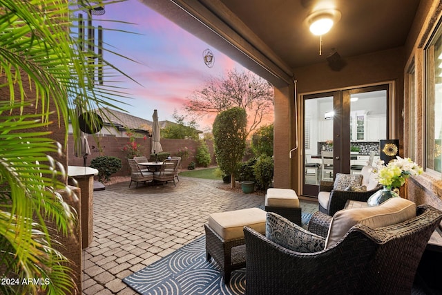 patio terrace at dusk featuring outdoor lounge area and french doors