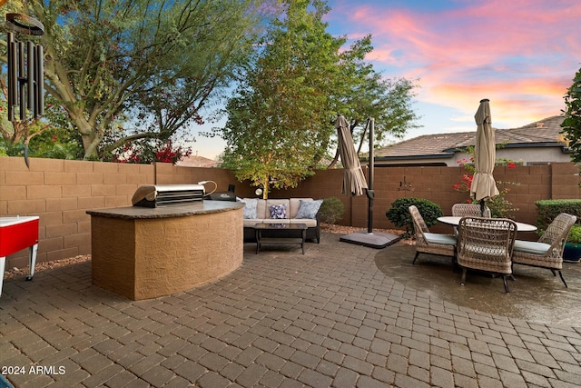 patio terrace at dusk with outdoor lounge area, area for grilling, and grilling area