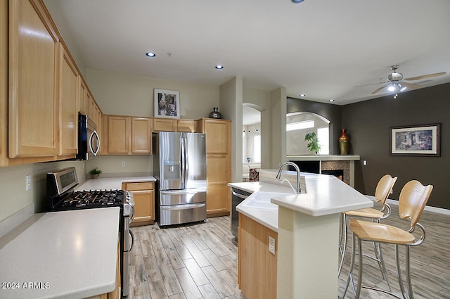 14430 N Agave Dr, Fountain Hills, AZ 85268 - kitchen featuring a kitchen island with sink, a kitchen breakfast bar, sink, light hardwood / wood-style floors, and stainless steel appliances