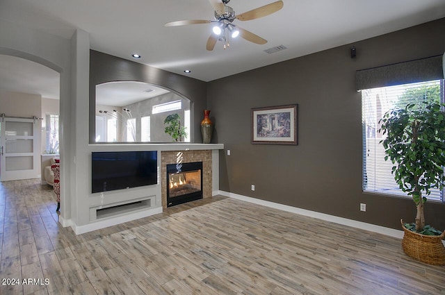 14430 N Agave Dr, Fountain Hills, AZ 85268 - unfurnished living room featuring ceiling fan, a tiled fireplace, and light hardwood / wood-style flooring