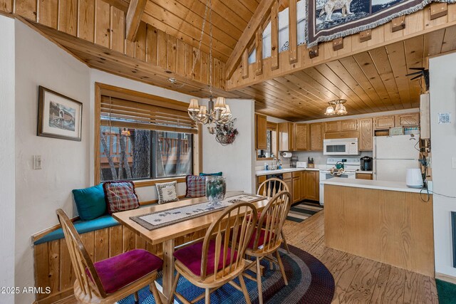dining room featuring vaulted ceiling, an inviting chandelier, light wood-style floors, and wood ceiling