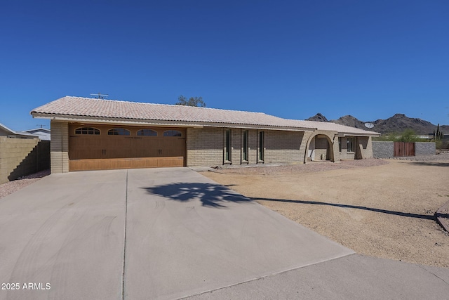 1530 E Loma Ln, Phoenix, AZ 85020 - single story home with concrete driveway, a mountain view, an attached garage, brick siding, and a tiled roof