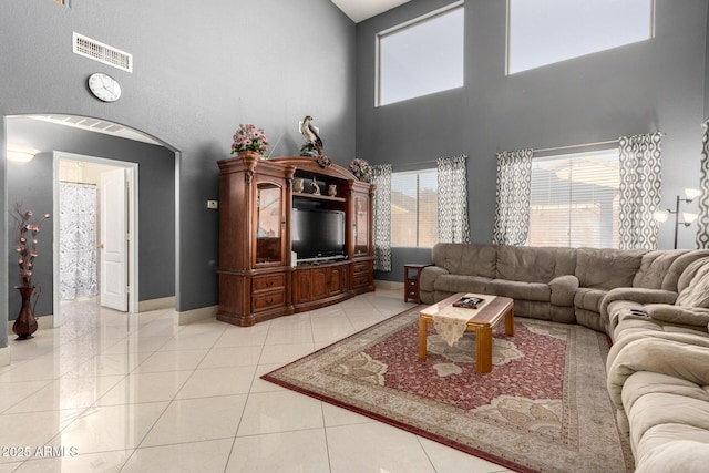 tiled living room featuring a high ceiling