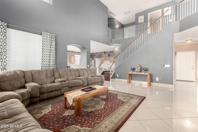 living room with light tile patterned flooring and a towering ceiling