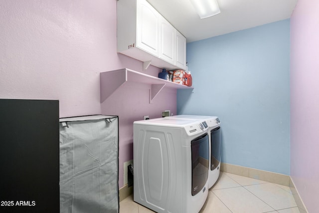 laundry room featuring light tile patterned floors, washing machine and dryer, and cabinets