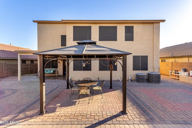 rear view of house with a gazebo, cooling unit, and a patio