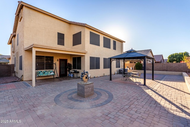 rear view of house with a gazebo and a patio