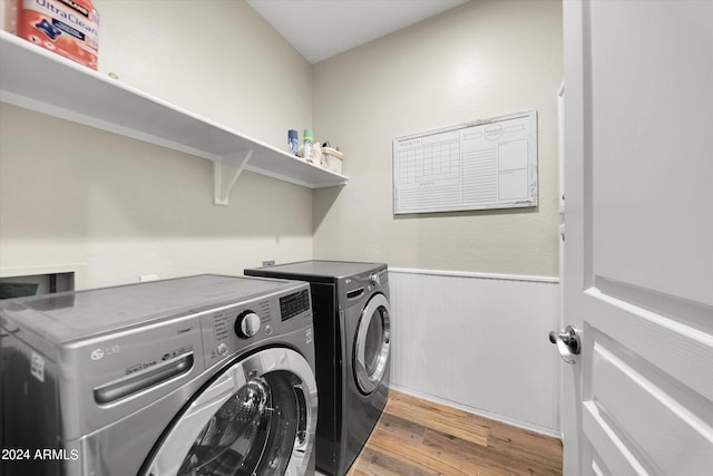 laundry area with washer and dryer and light hardwood / wood-style floors