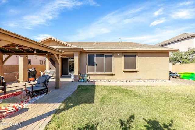 back of house featuring a lawn and a patio area