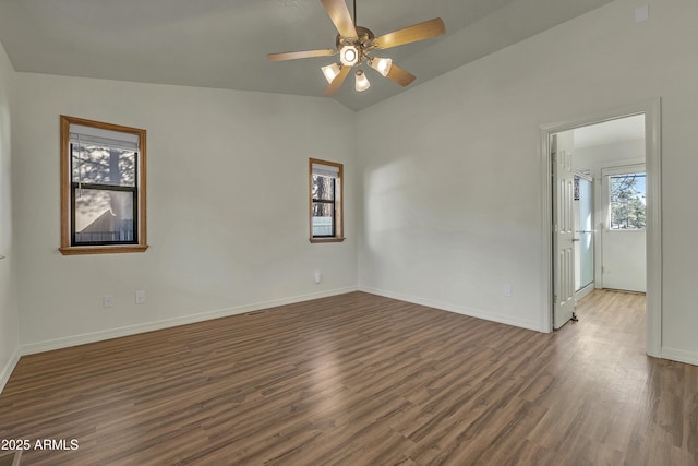 unfurnished room featuring baseboards, lofted ceiling, a ceiling fan, and wood finished floors